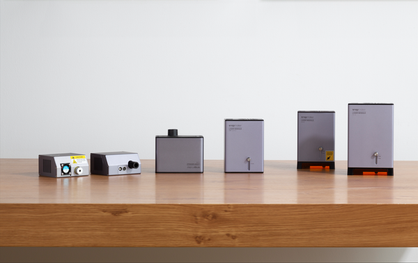 A lineup of six different Snapmaker laser modules arranged on a wooden table.